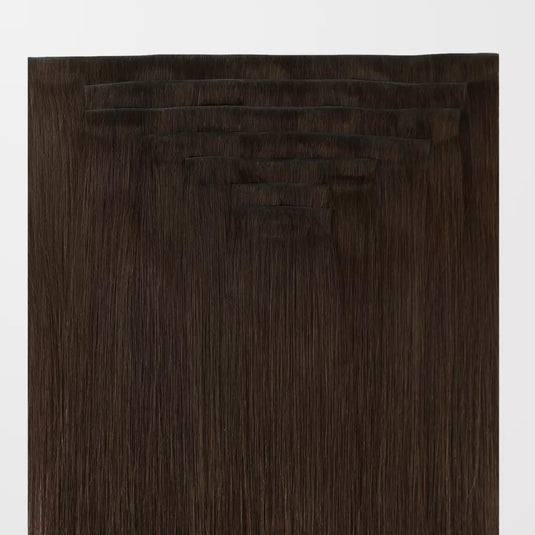 Set of brown clip hair extensions on a white background