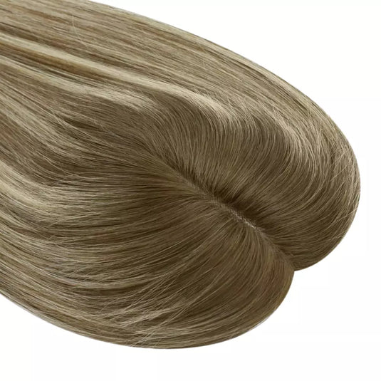 Light brown hair topper on a white background