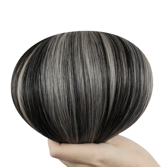 Hand holding a butterfly weft with black with silver highlight color on a white background