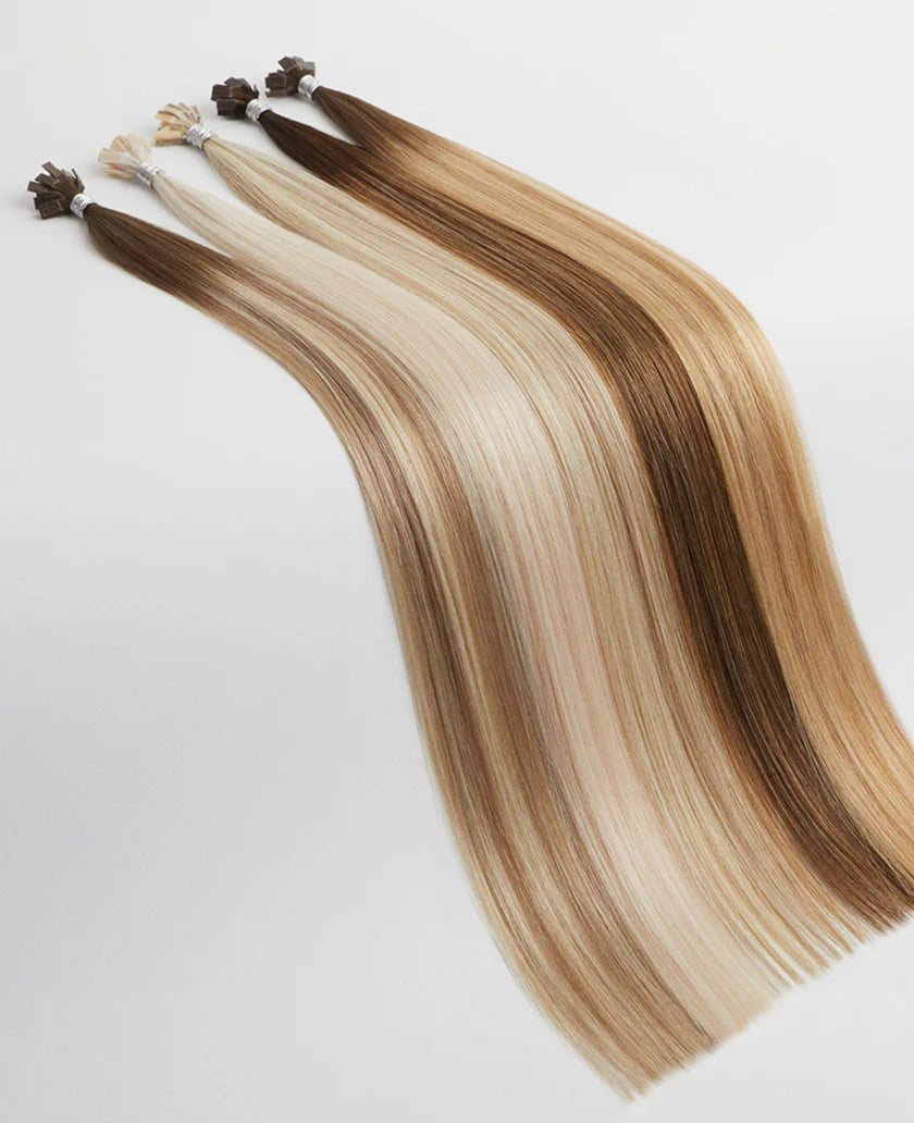 Set of hair extensions with brown to blonde gradient on a white background