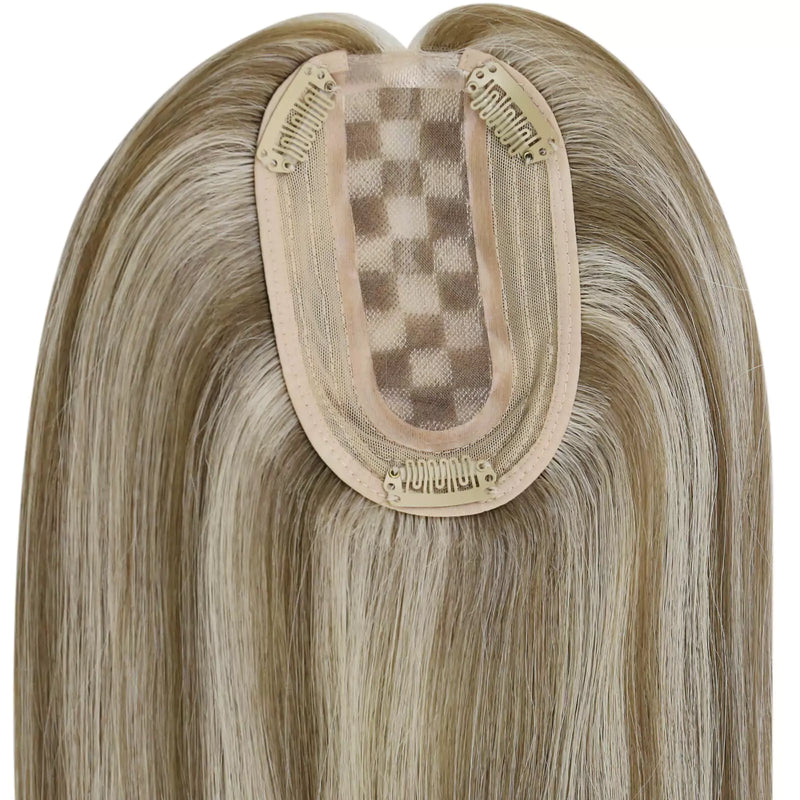 Load image into Gallery viewer, A close-up of a straight hairpiece section, showing the beige adhesive base and blonde mesh with clip-in springs, on a plain white background
